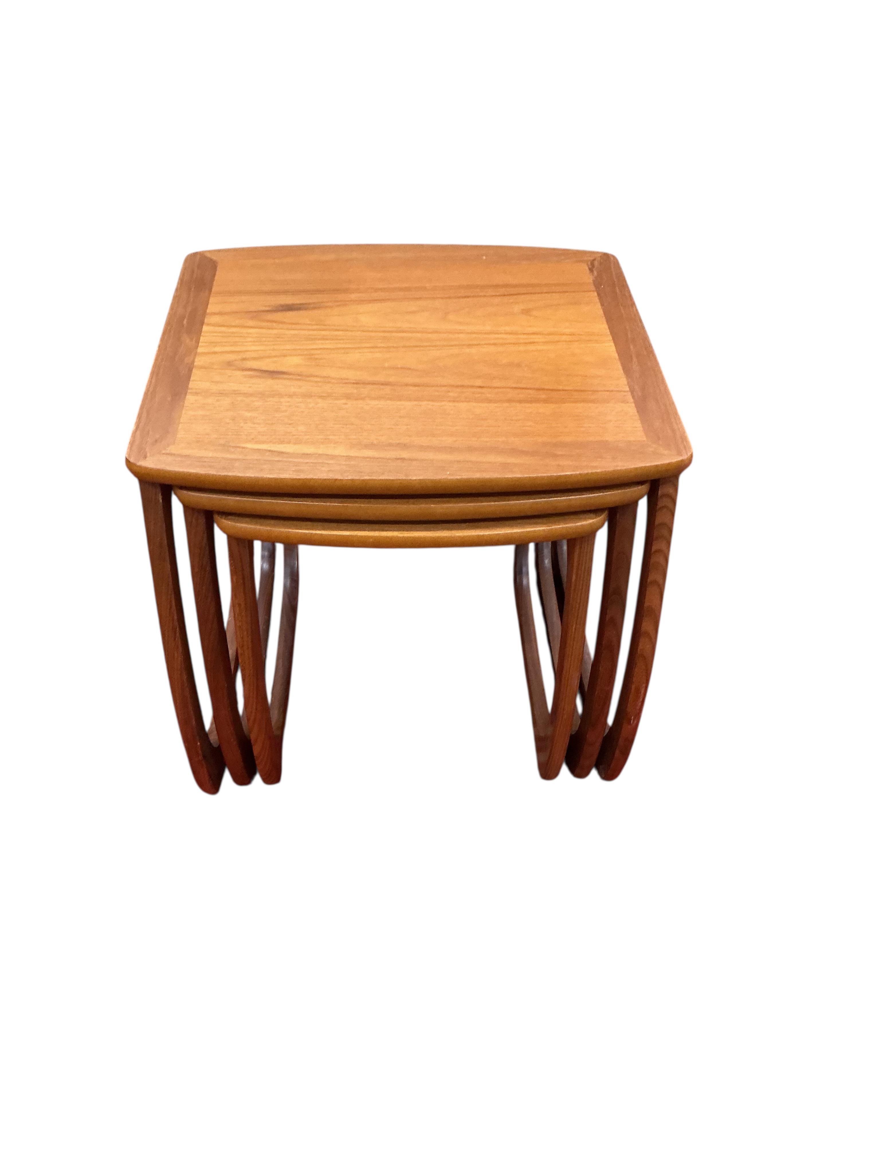 A nest of three mid century Nathan teak tea tables, width 52cm, depth 48cm, height 50cm together with a mid century teak coffee table